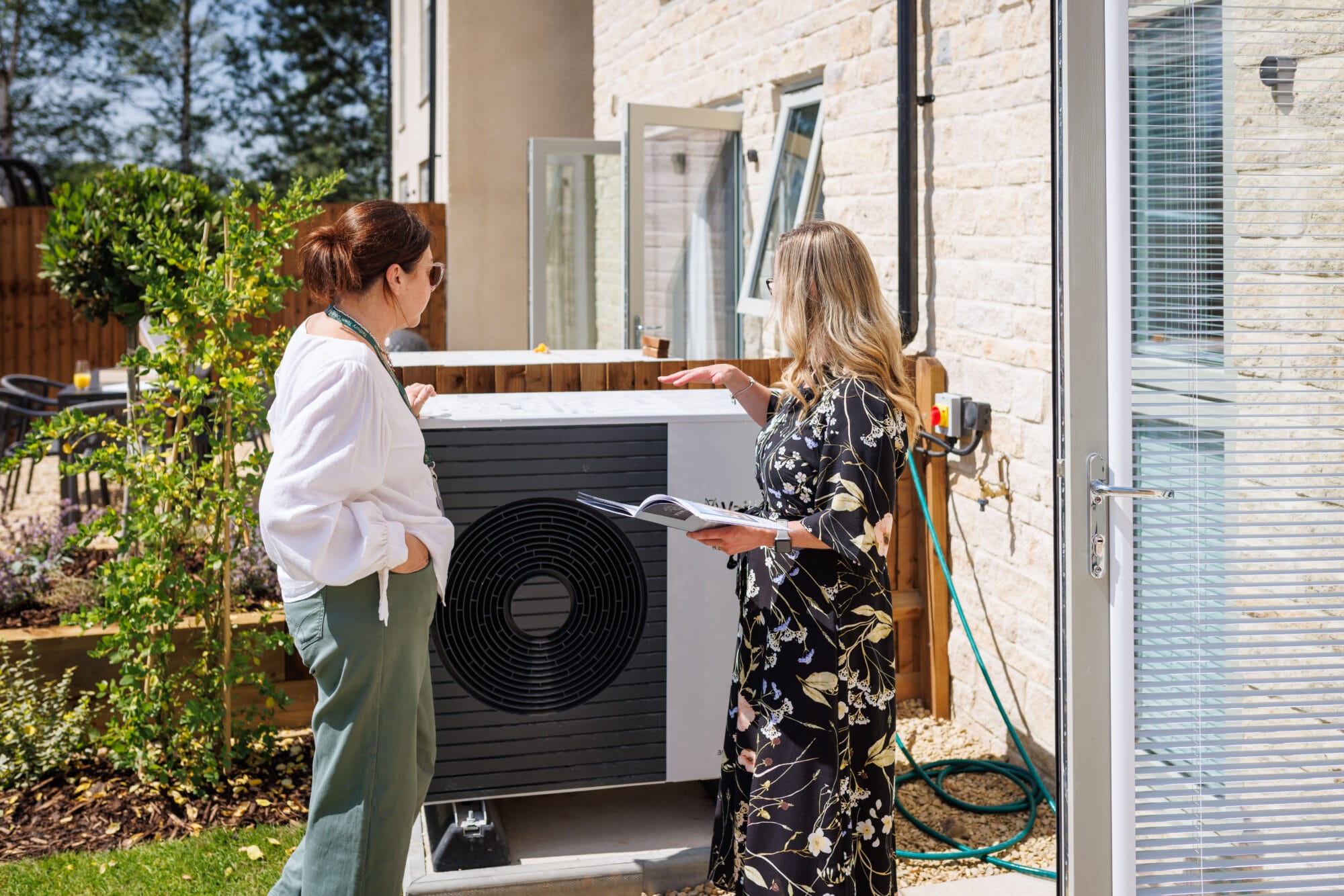 Team and stakeholders discuss air source heat pumps at a development of zero carbon homes by Newland Homes